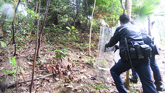 警方手持盾牌在山坡戒備阻截野豬
