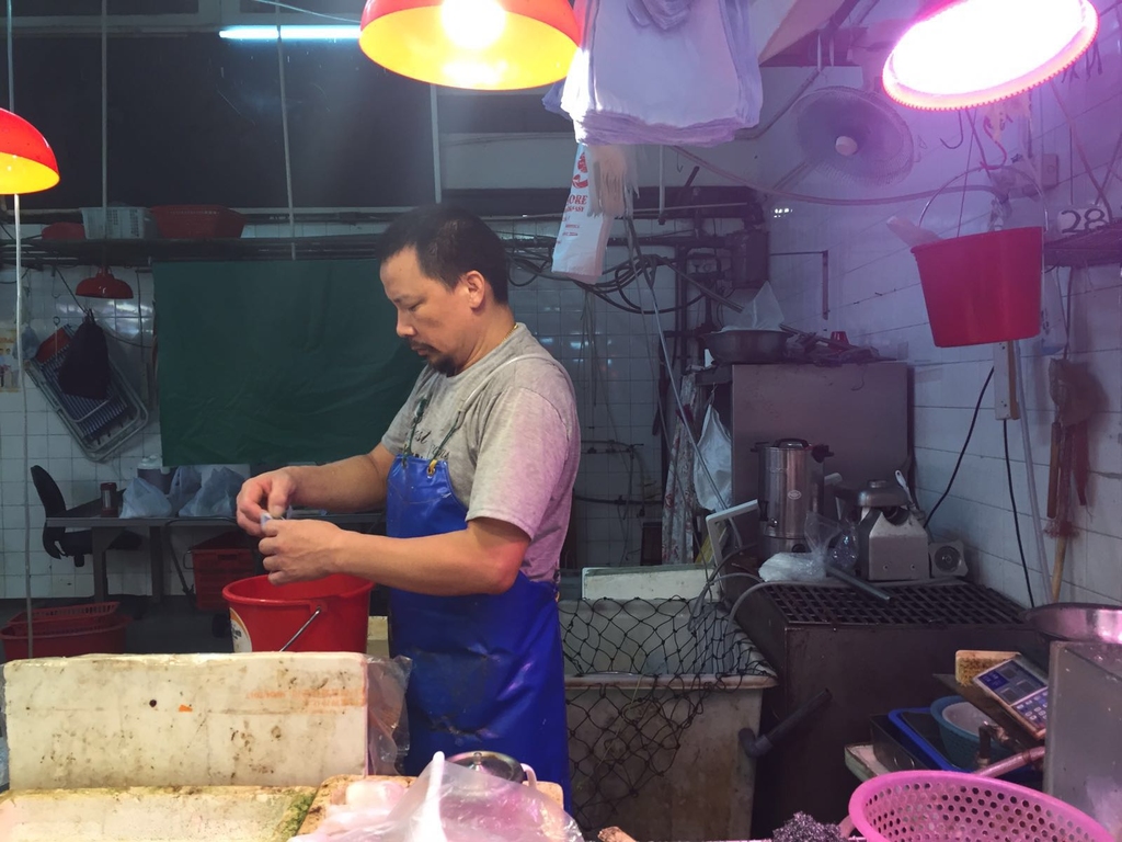 魚檔負責人王先生指市民今日多買餸菜，明天備用。(張雅婷)
