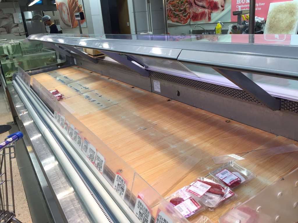 超市肉櫃平日晚上7時仍有貨，今日下午已被掃剩幾包豬骨。(張雅婷攝)