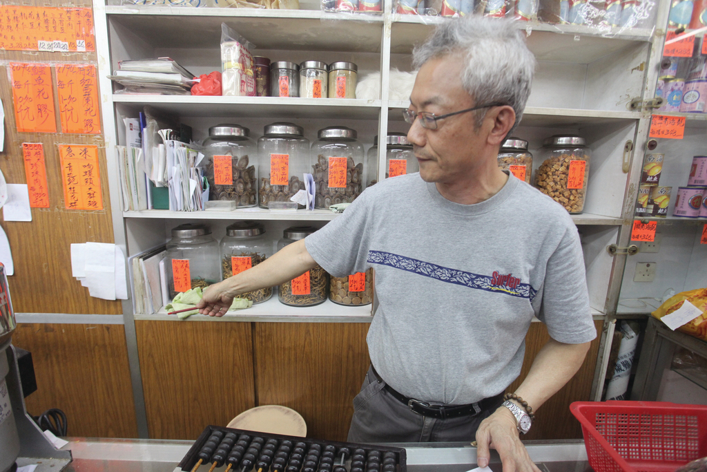 永樂街參葺藥材店「永和興」職員李先生指，店內仍留有當年水浸及腰的痕跡。(劉定安攝)