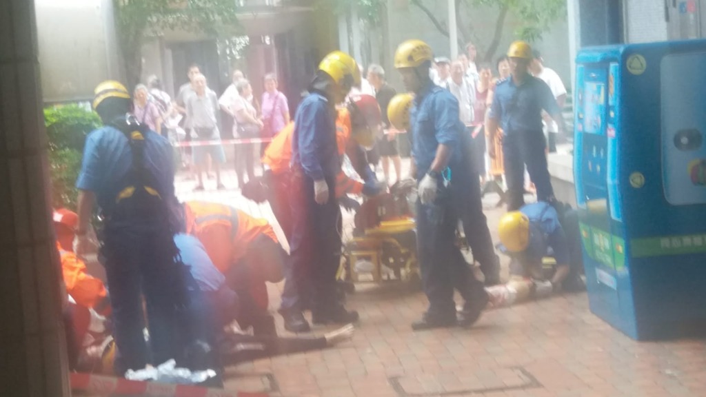消防救護人員正在場協助兩名墮樓母子(讀者提供)