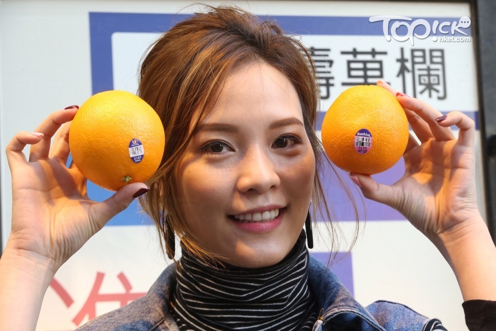 進濤菓欄負責人Gigi教路，買橙時留意愈大愈甜，手執橙時愈「墜手」愈好。（張永康攝）