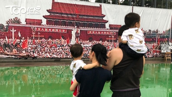從內地來港旅遊的王先生（右）攜妻兒出席晚會。（經濟日報記者攝）