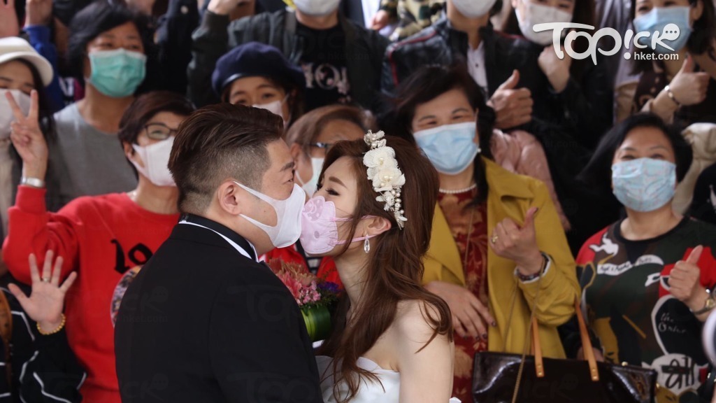 一對新婚夫婦今日在尖沙咀文化中心註冊，親友們都戴上口罩。（陳國峰攝）