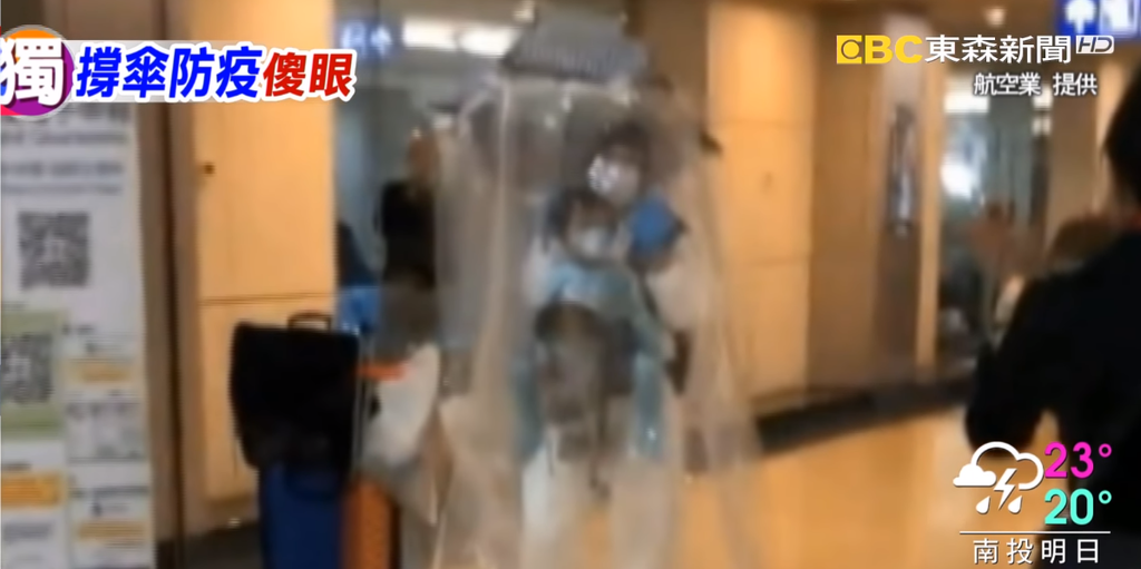媽媽落機換上另一把「防護傘」，罩著母女全身。（影片截圖）