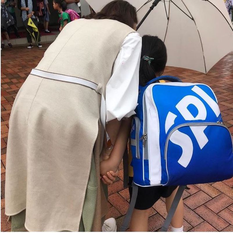 黎姿彎腰似跟女兒說話，雨傘都偏向女兒那邊，深怕她被雨淋濕。（相片來源︰IG @gigilai_official）