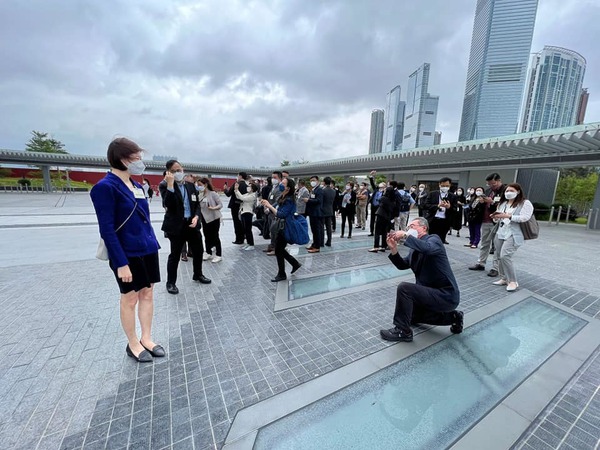 唐英年單膝下跪「傾力」為容海恩拍照。(容海恩Facebook)