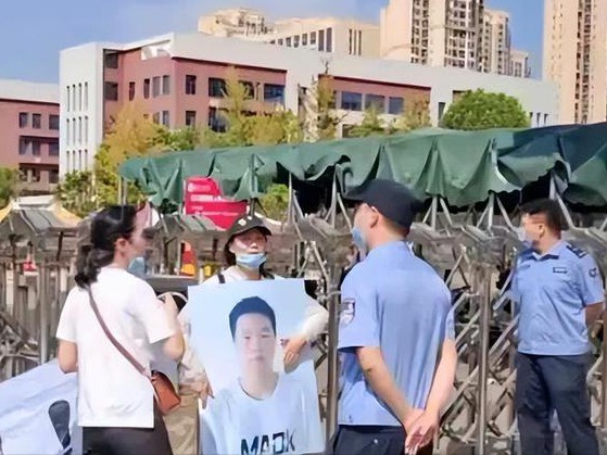 家屬到校門口舉牌,維權抗議。(資料圖片)