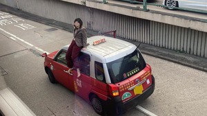 灣仔女子危坐的士車頂。（Facebook  馬路的事 (即時交通資訊台)）
