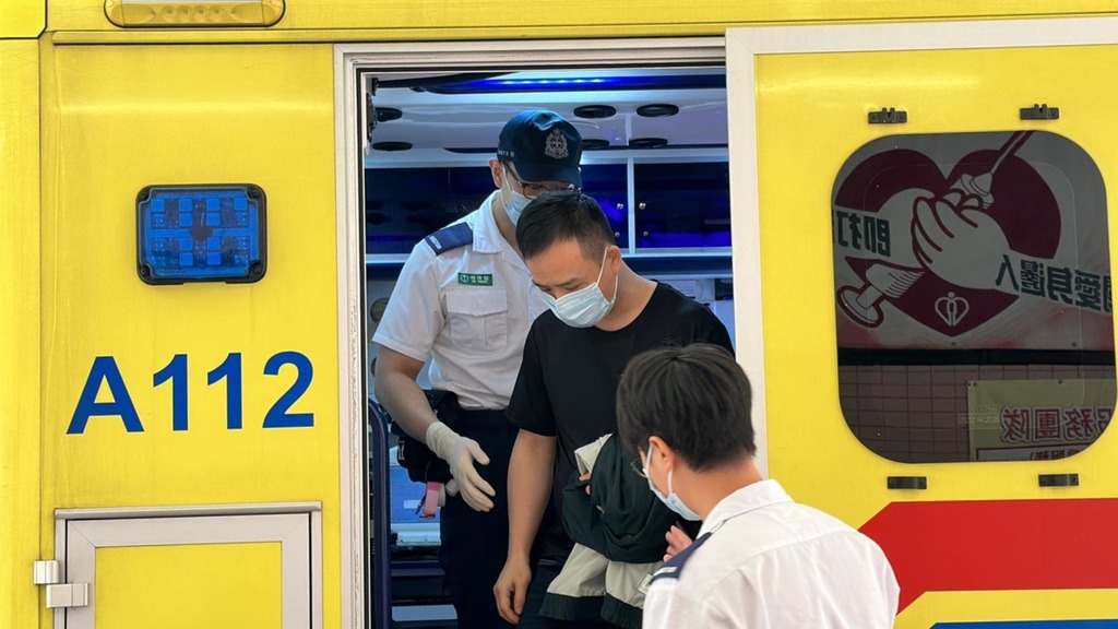 灣仔餐廳女職員揮刀斬人，男同事（黑衣男）左手及背部受傷。