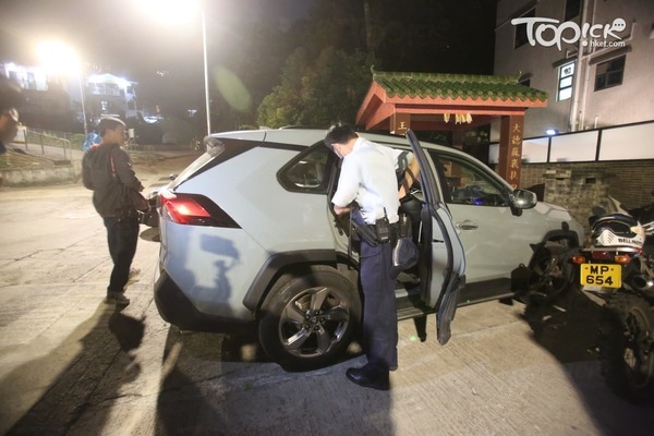 有警員檢走私家車上兩個旅行袋調查。(黃傑偉攝)
