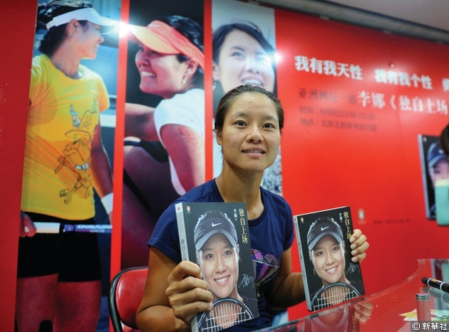 李娜在2012年一簽售活動上展示其自傳《獨自上場》，該書紀錄了她30年來的成才之路、賽場傳奇以及不為人知的故事。(相片來源：新華社)